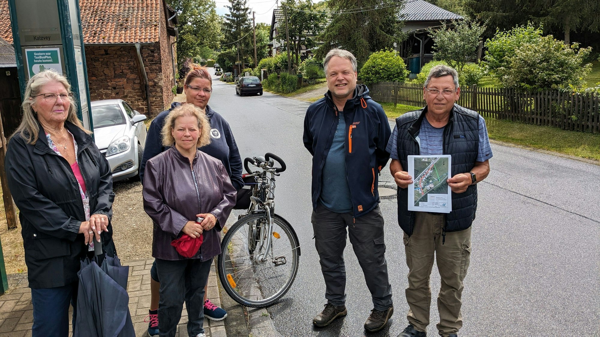 Bürgerinnen und Bürger aus Alt-Katzvey stehen an der Straße „Am Katzenstein“.