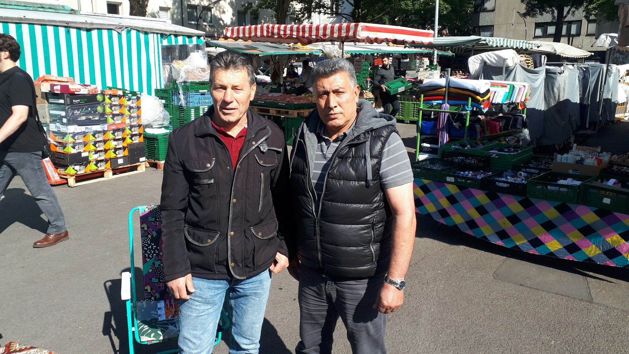 Der Nippeser Marktsprecher Mustafa Özcan (l.) und Markthändler Artik Mus klagen über zu knappe Auf- und Abbauzeiten für die Marktleute. Bei Überschreitungen drohen Sanktionen der Marktleitung.