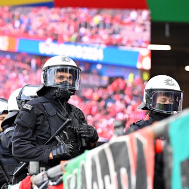 Zu sehen sind Einsatzkräfte der Polizei in einem Fußballstadion.