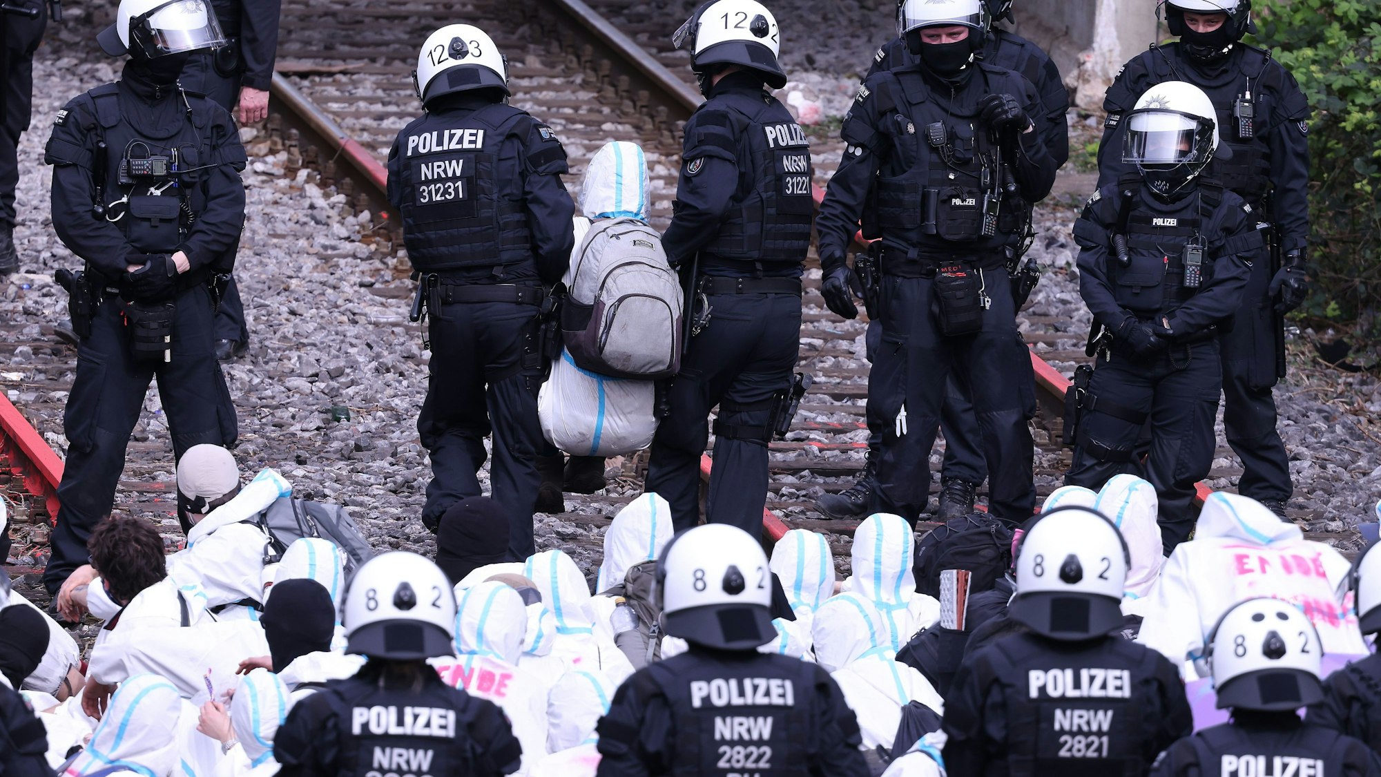 Ein Klimaschutzaktivist der Gruppe «Ende Gelände», der Schienen der Zufahrt zu dem Kohlekraftwerk Scholven in Gelsenkirchen blockiert hatte, wird von Polizisten weggetragen.
