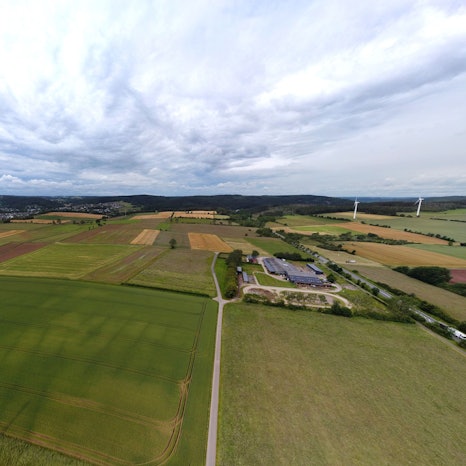 Luftbild mit Äckern, Wiesen und einem Reiterhof.