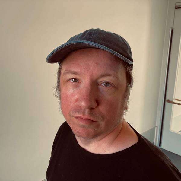 Der Duisburger Dirk Hähnel reparierte in einer Werkstatt für Menschen mit Behinderungen Computerbildschirme – und erhielt dafür 1,35 Euro pro Stunde. Er ist im Porträt zu sehen, trägt eine Baseballcap und schaut zweifelnd-lächelnd in die Kamera.