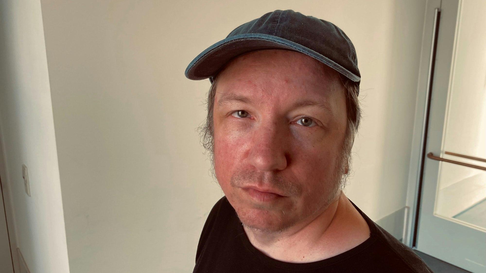 Der Duisburger Dirk Hähnel reparierte in einer Werkstatt für Menschen mit Behinderungen Computerbildschirme – und erhielt dafür 1,35 Euro pro Stunde. Er ist im Porträt zu sehen, trägt eine Baseballcap und schaut zweifelnd-lächelnd in die Kamera.