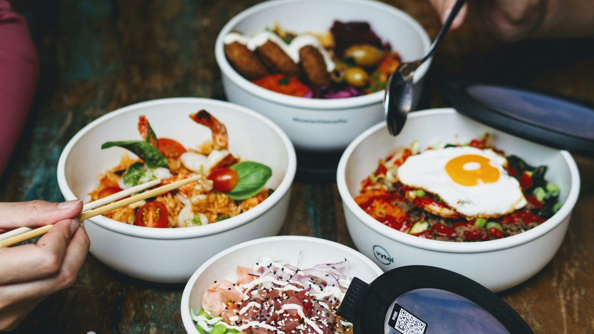 Mehrere Personen essen aus Mehrwegschalen des Start-ups Vytal.