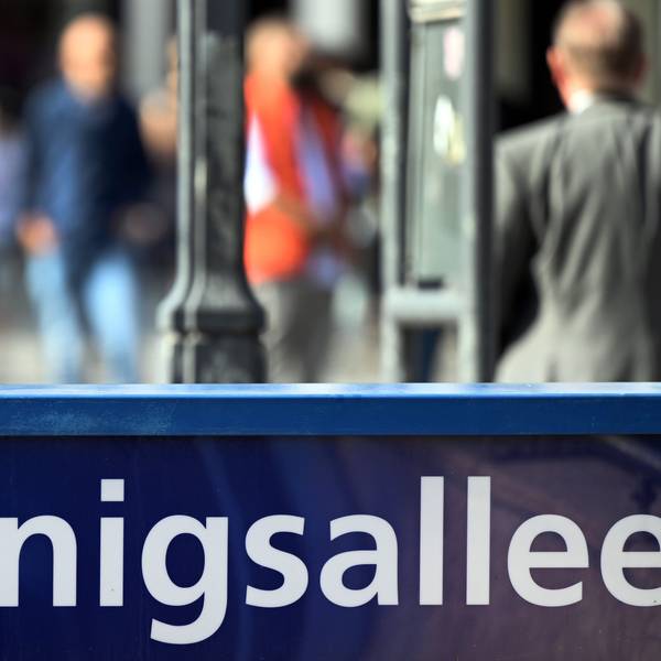 Menschen flanieren auf der Düsseldorfer Prachtstraße Königsallee.