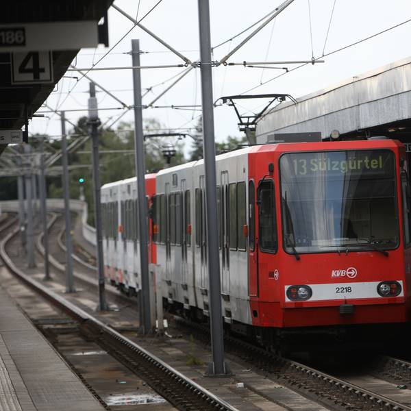 Eine Bahn der Linie 13 Richtung Sülzgürtel hält gerade an einer Haltestelle.