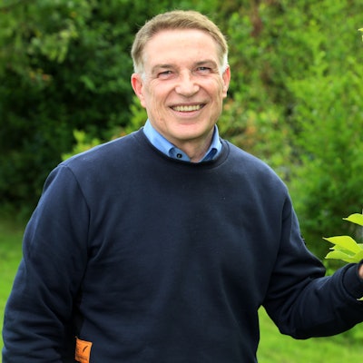 Der langjährige Kreisdirektor des Rheinisch-Bergischen Kreises, Dr. Erik Werdel, steht an einem Baum im Garten seines Hauses in Overath-Heiligenhaus.