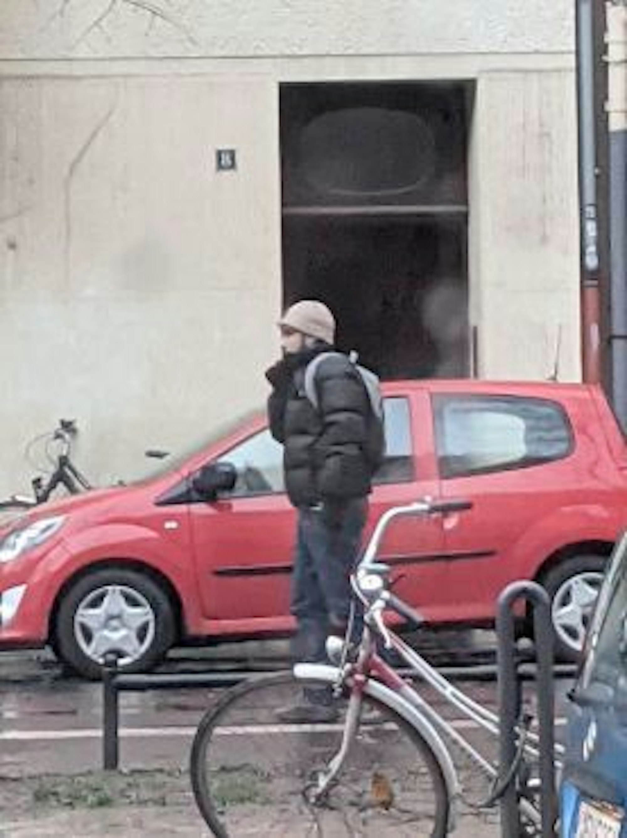 Mann in schwarzer Daunenjacke läuft über eine Straße