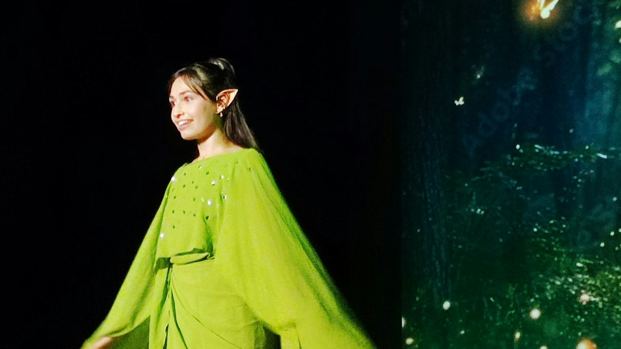 Eine Schülerin, verkleidet als Elfe, mit grünem Gewand und spitzen Ohren.