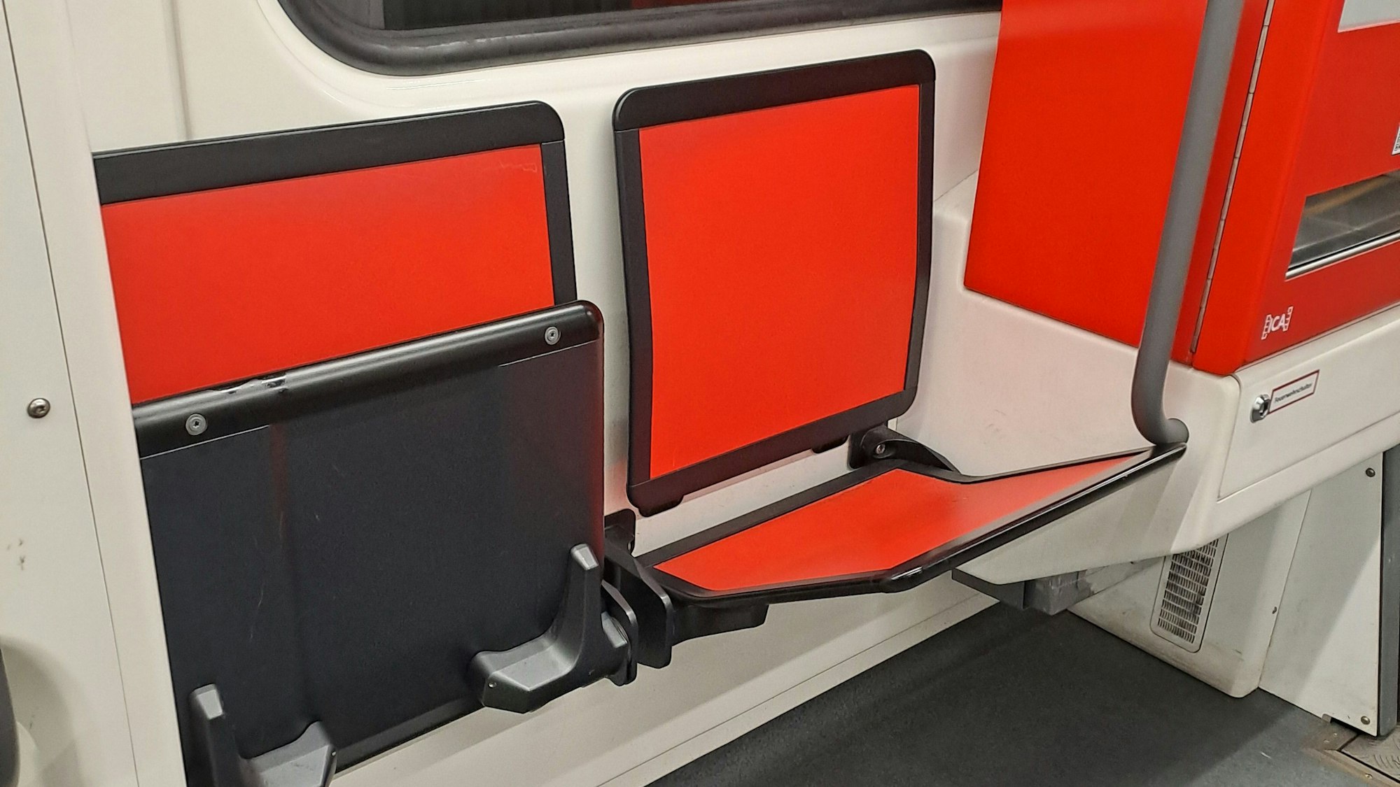 zwei rote Klappsitze in einer Bahn der KVB