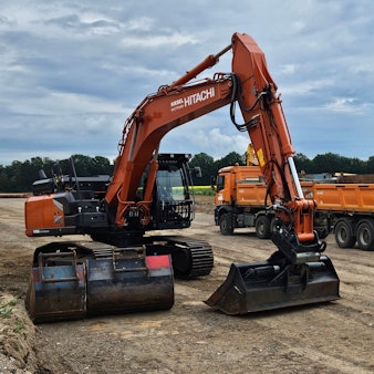 Ein Bagger und ein Bau-Lkw sind auf einem Bau-Abschnitt zu sehen.