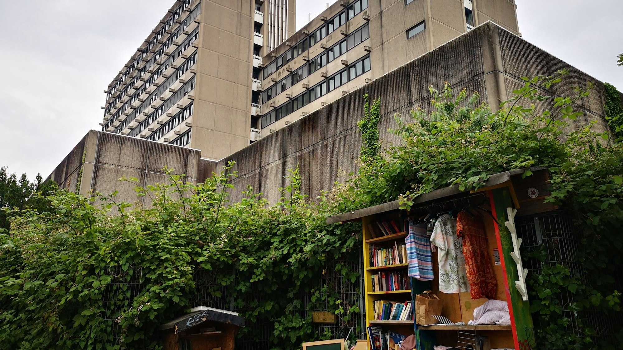 Vor dem Gebäude ist ein öffentlicher Tausch-Stand untergebracht. Auch er wirkt etwas verwahrlost.