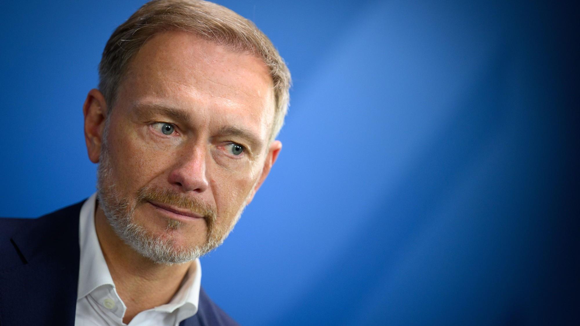 Es ist Christian Lindner (FDP), Bundesminister der Finanzen, vor einem blauen Hintergrund zu sehen.