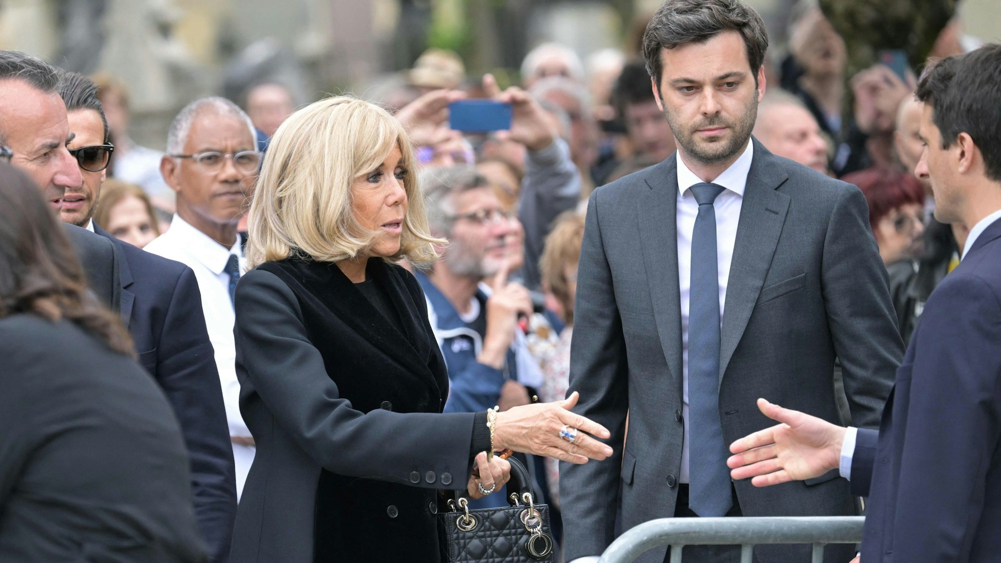 Die Ehefrau des französischen Präsidenten, Brigitte Macron (l), flankiert von einem ihrer Berater, Tristan Bromet (2r), nimmt an der Trauerfeier für die verstorbene französische Sängerin Françoise Hardy auf dem Friedhof Père Lachaise teil.