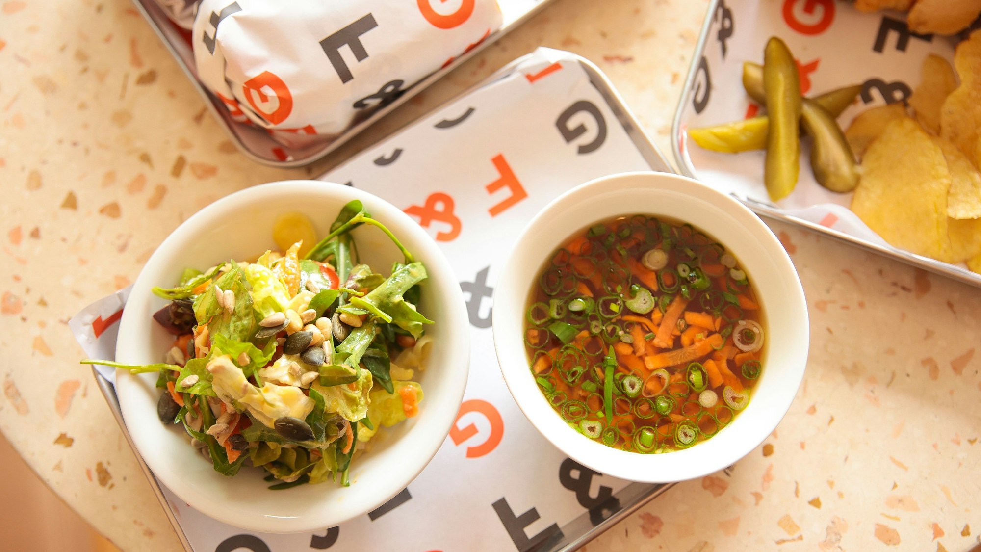 Die Hühnersuppe mit kleinem Salat ist auf einem Tisch zu sehen.