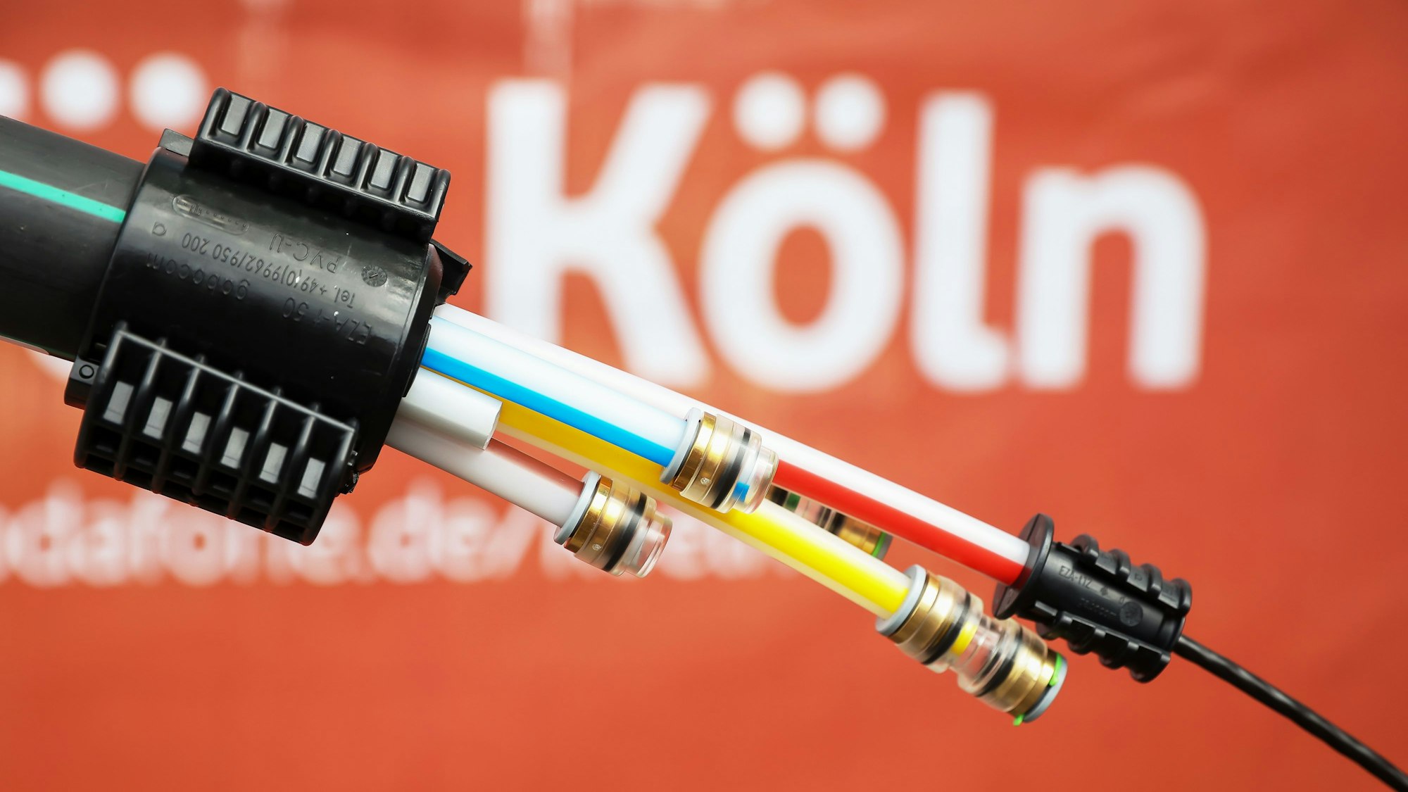 Ein Glasfaserkabel von Vodafone vor rotem Hintergrund.