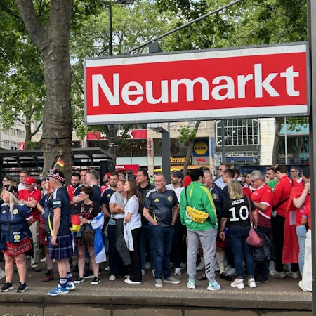 Fußballfans aus Schottland und der Schweiz warten am Donnerstag vor dem Spiel im Rhein-Energie-Stadion am Neumarkt auf die Straßenbahn.