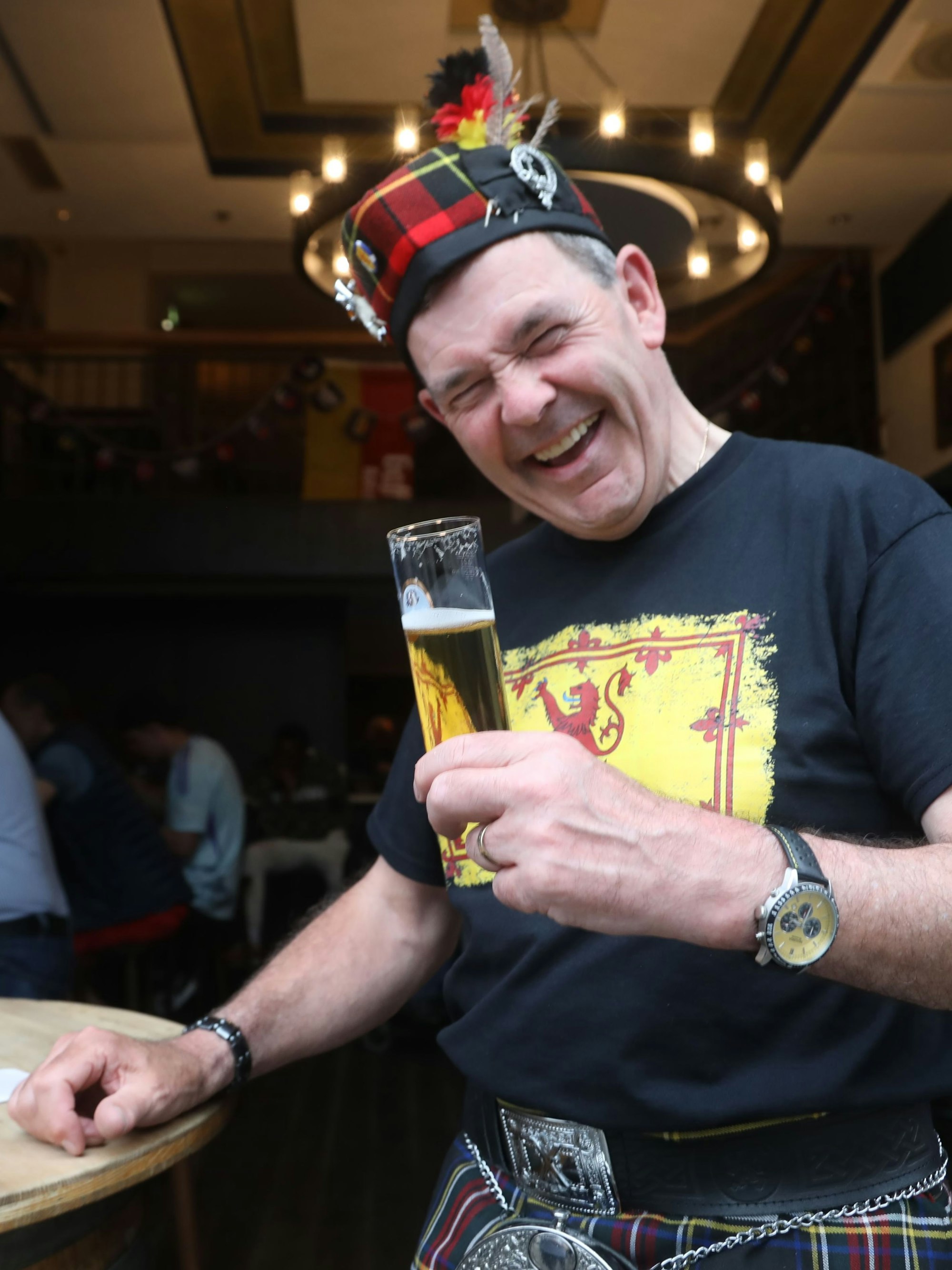 Mann mit Schottenrock und Kölsch in der Hand