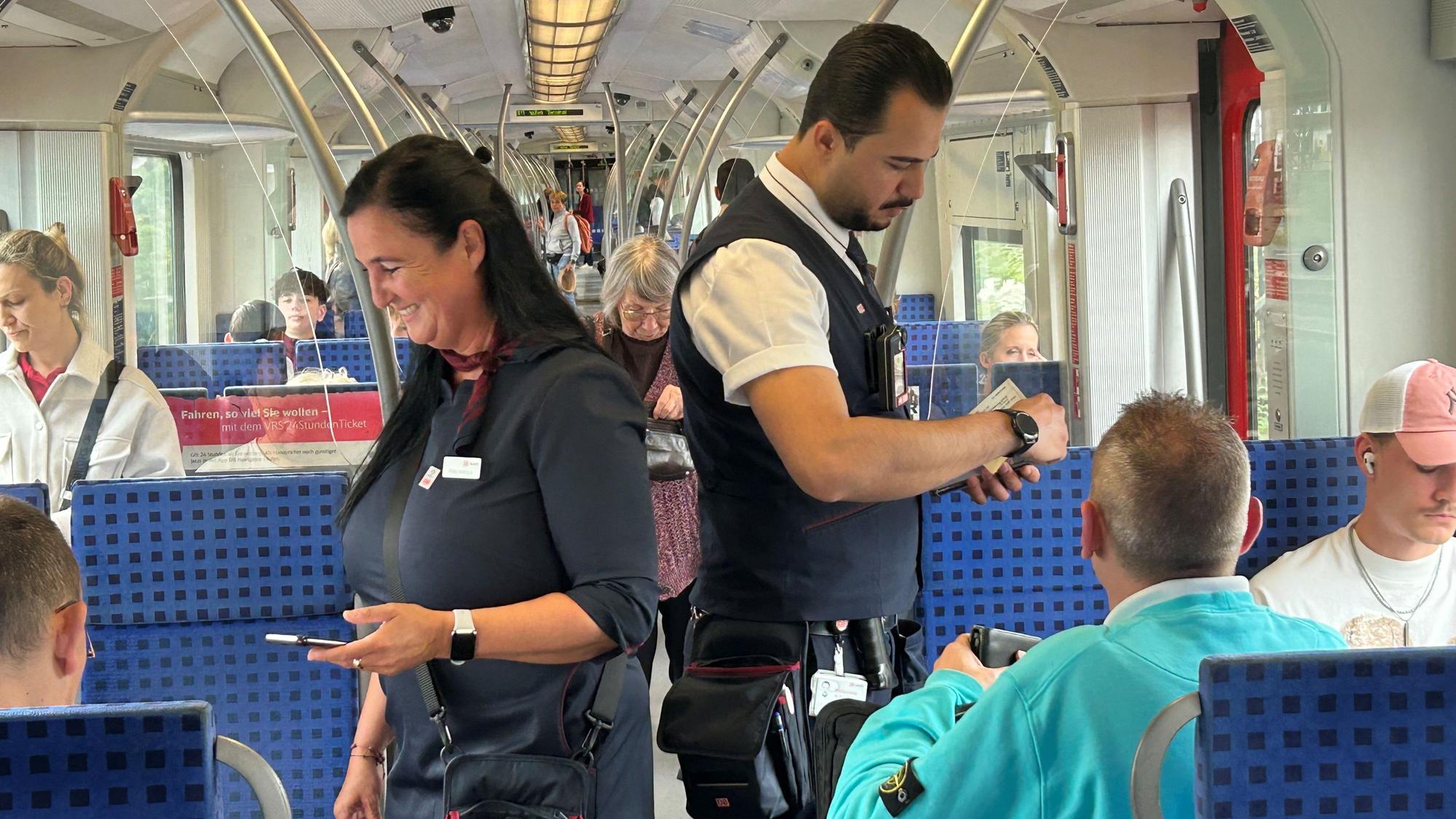Die Zugbegleiter Nicole Arnold und Jalal Youssef kontrollieren die Tickets in einer Kölner S-Bahn.