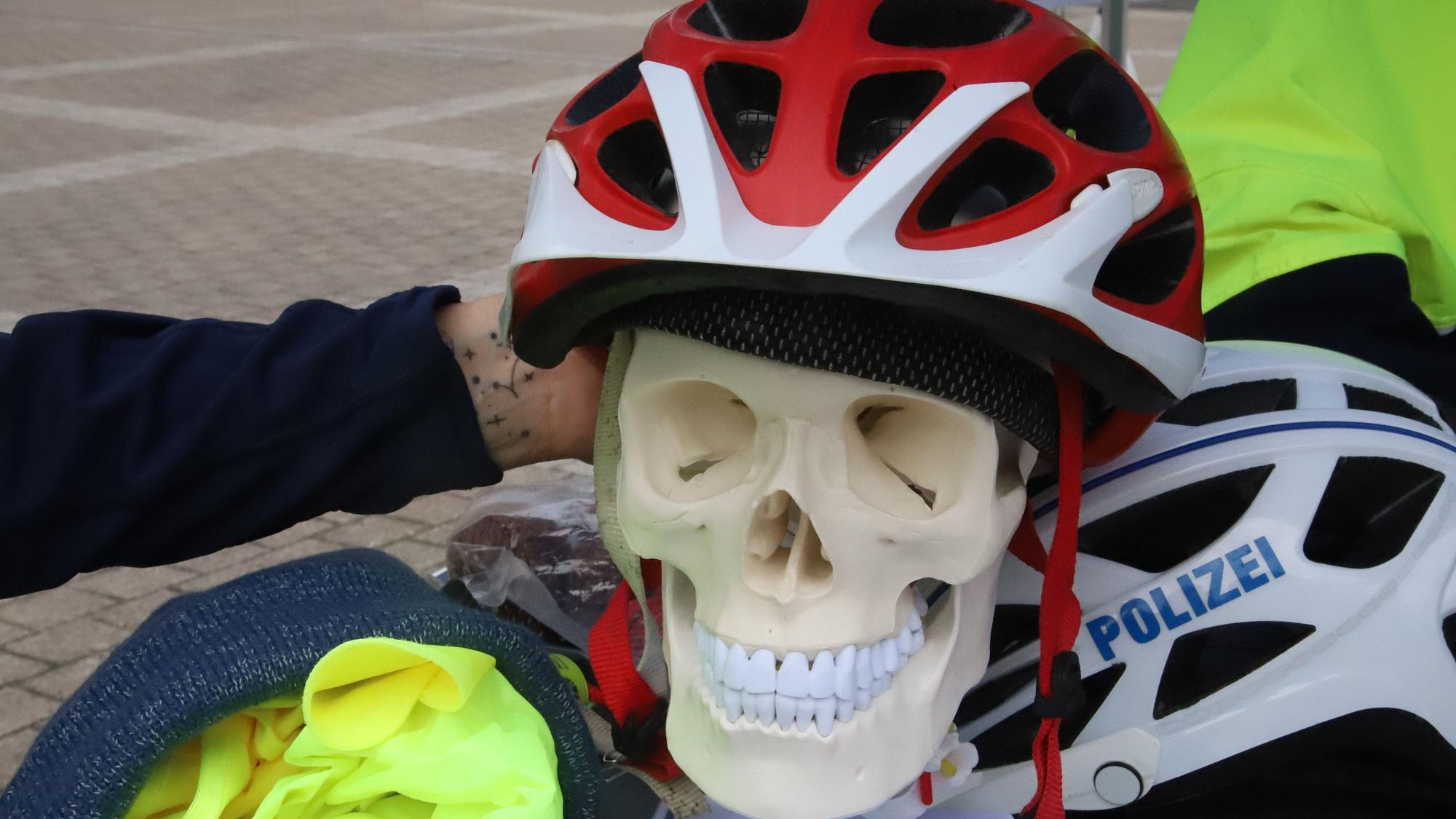 Auf einem Kunstschädel ist ein Fahrradhelm aufgesetzt.