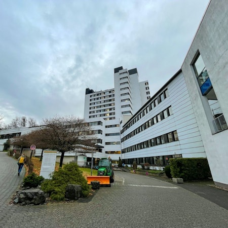 Das Marienkrankenhaus in Bergisch Gladbach, davor stehen ein Schild und ein Baum.