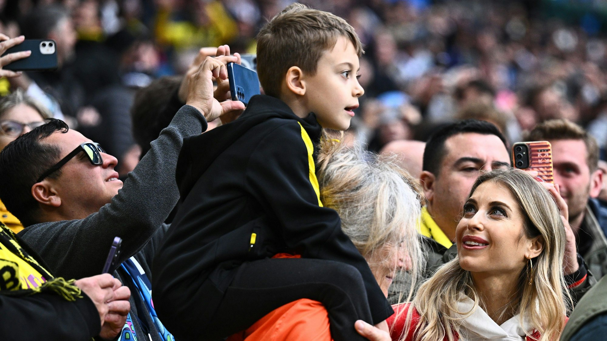 TV-Moderator Cathy Hummels steht neben ihrem Sohn Ludwig auf der Tribüne.
