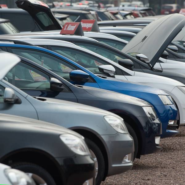 Neu- und Gebrauchtwagen stehen bei einem Autohändler nebeneinander.
