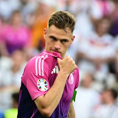 Joshua Kimmich steht im pinken Auswärtstrikot der deutschen Nationalmannschaft auf dem Platz.