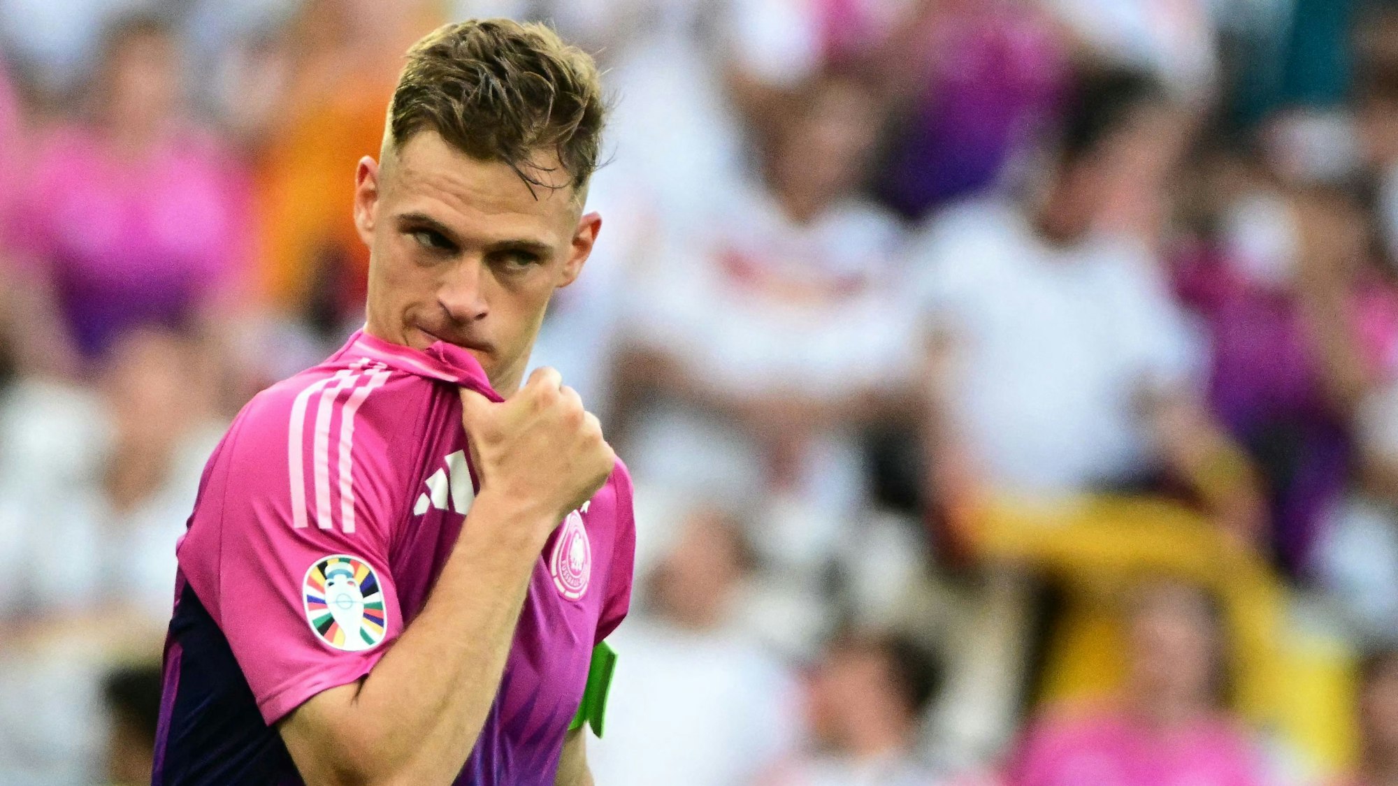 Joshua Kimmich steht im pinken Auswärtstrikot der deutschen Nationalmannschaft auf dem Platz.