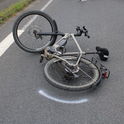 Ein in einen Unfall verwickeltes Pedelec liegt auf der Straße, daneben ist eine Polizeimarkierung.