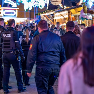 Polizeibeamte gehen über das Kirmesgelände Hohen Steinert.