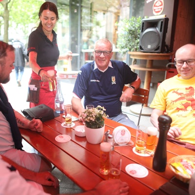 Schottische Fans und eine Kellnerin, die ihnen Kölsch bringt.