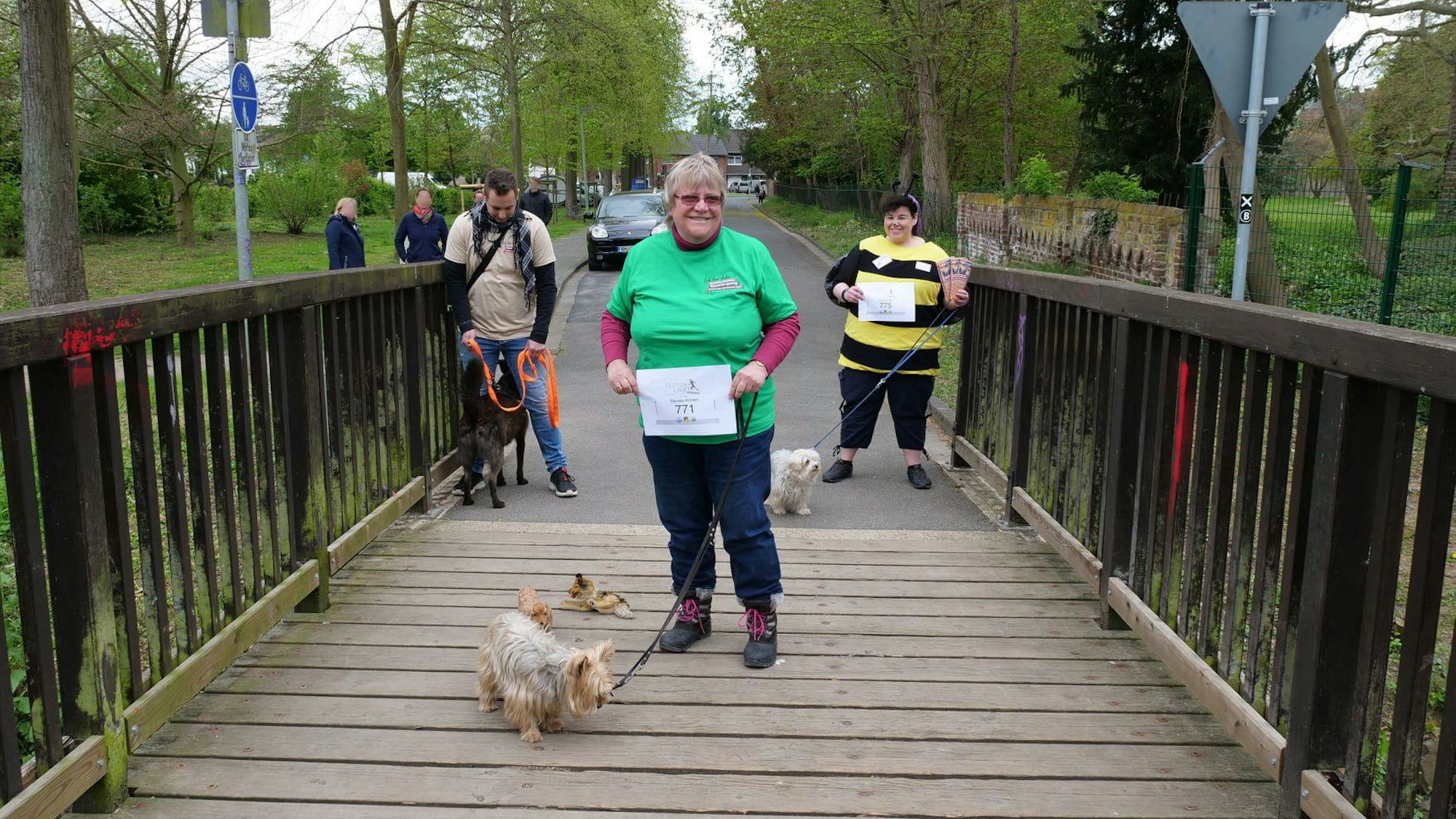 Zu sehen ist eine Frau, die einen Hund an der Leine führt.