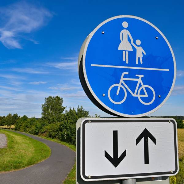 Das Bild zeigt einen Weg mit einem Verkehrsschild «Gemeinsamer Geh- und Radweg».