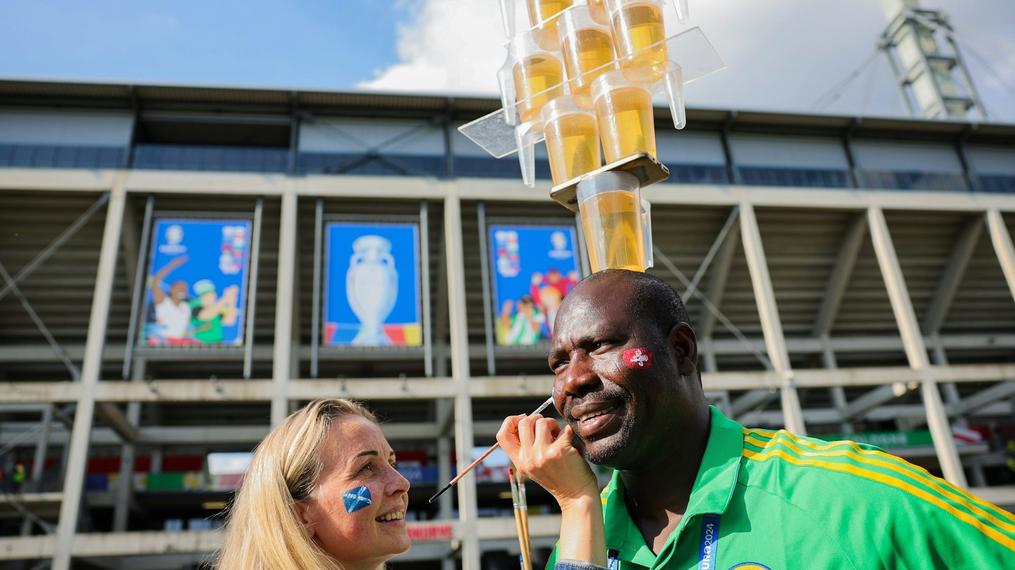 Lena aus der Ukraine malt Mohammed eine schottische Fahne auf die Wange.