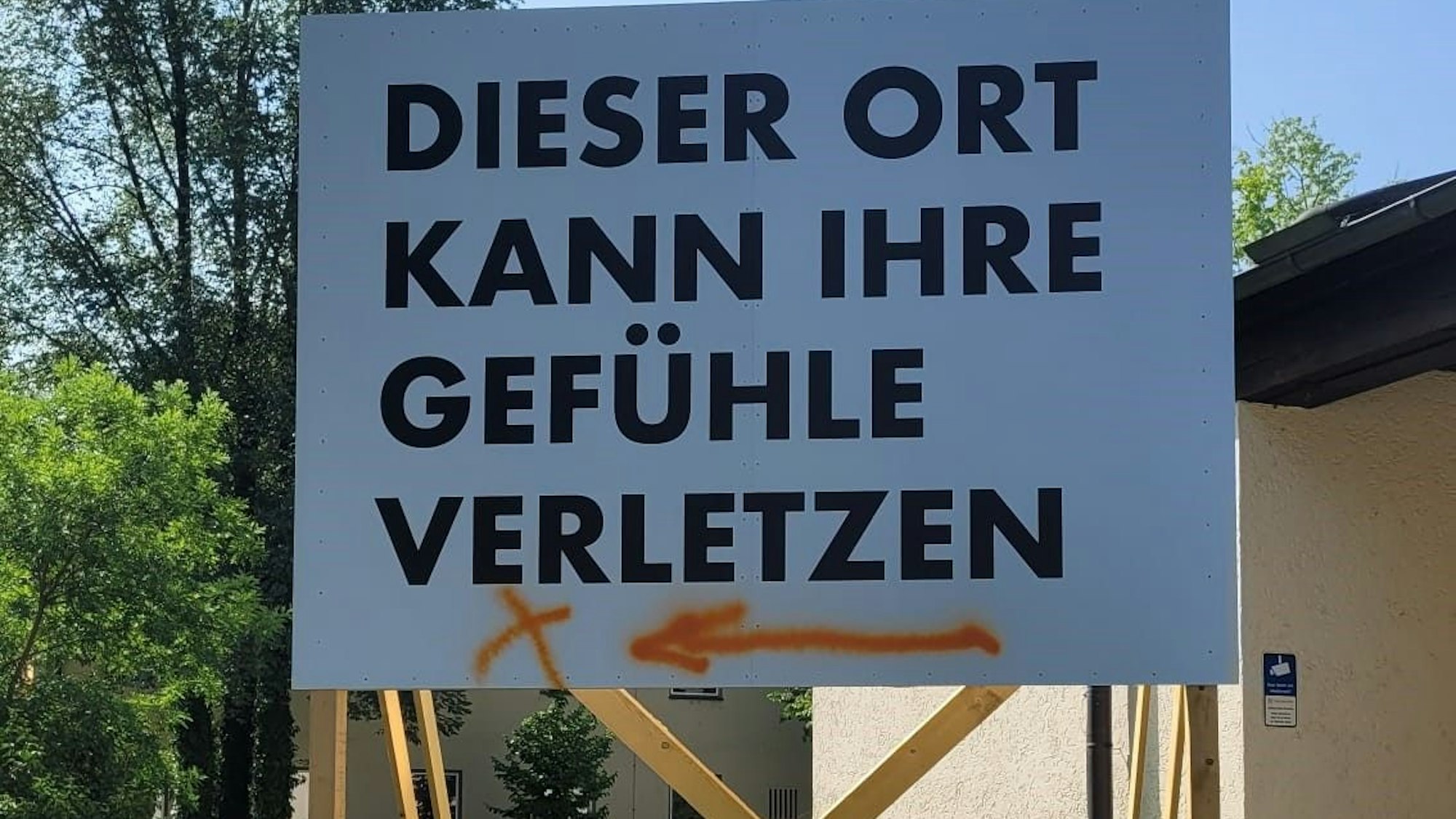 Eine aufgeständerte Tafel mit Aufschrift „Dieser Ort kann ihre Gefühle verletzen “