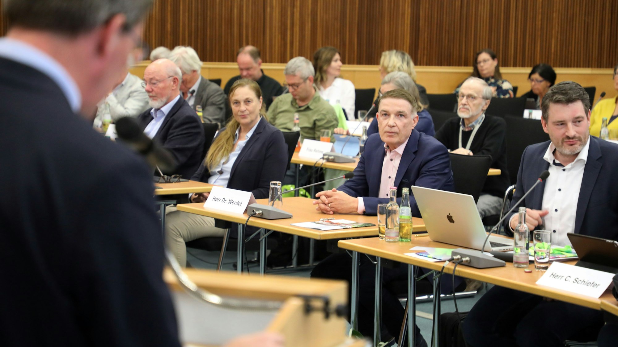 Ex-Kreisdirektor Dr. Erik Werdel sitzt zwischen Politikern im Kreistag, Landrat Stephan Santelmann spricht am Rednerpult.