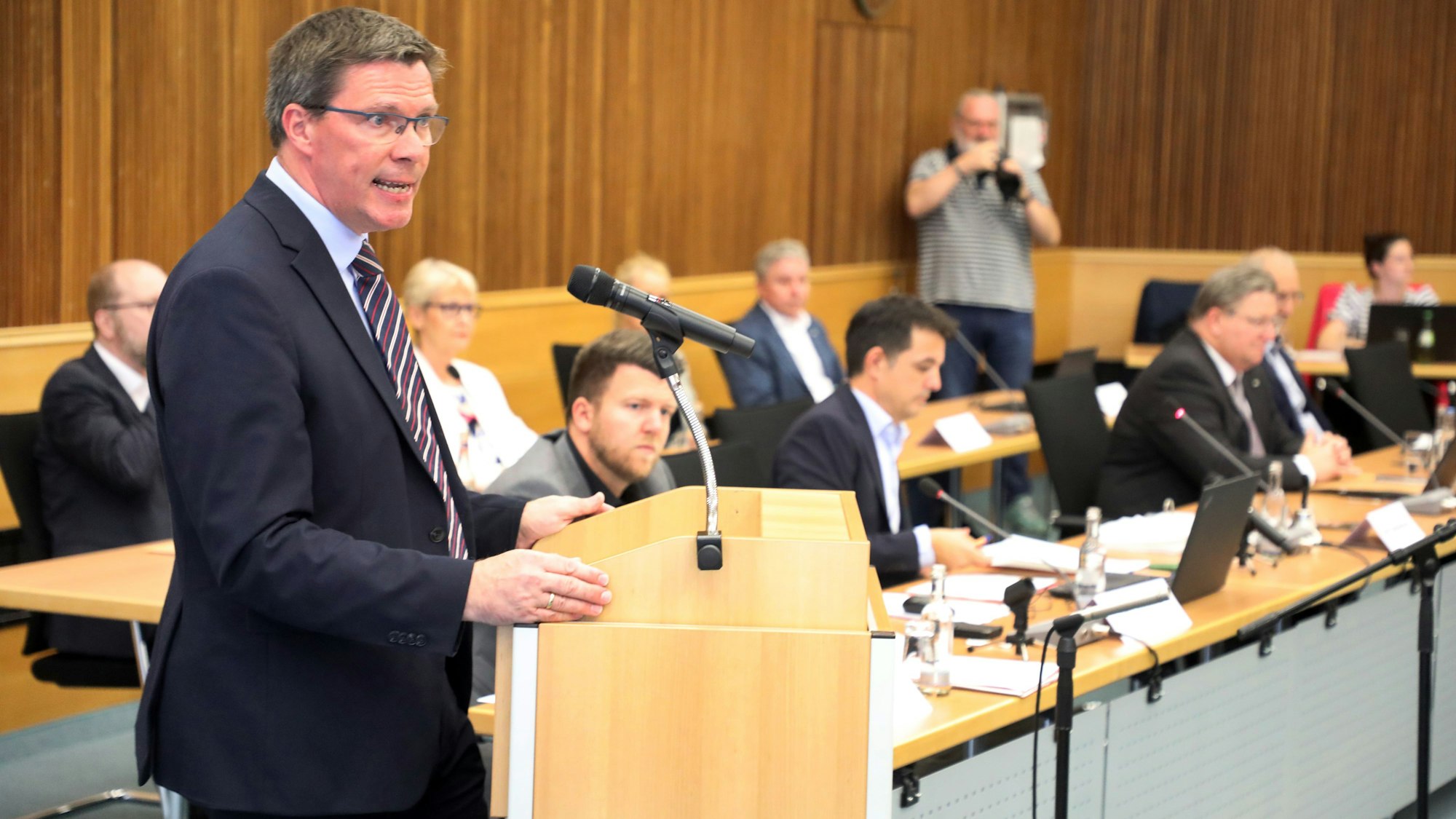 Landrat Stephan Santelmann steht am Rednerpult im großen Sitzungssaal des Kreishauses am Rübezahlwald.