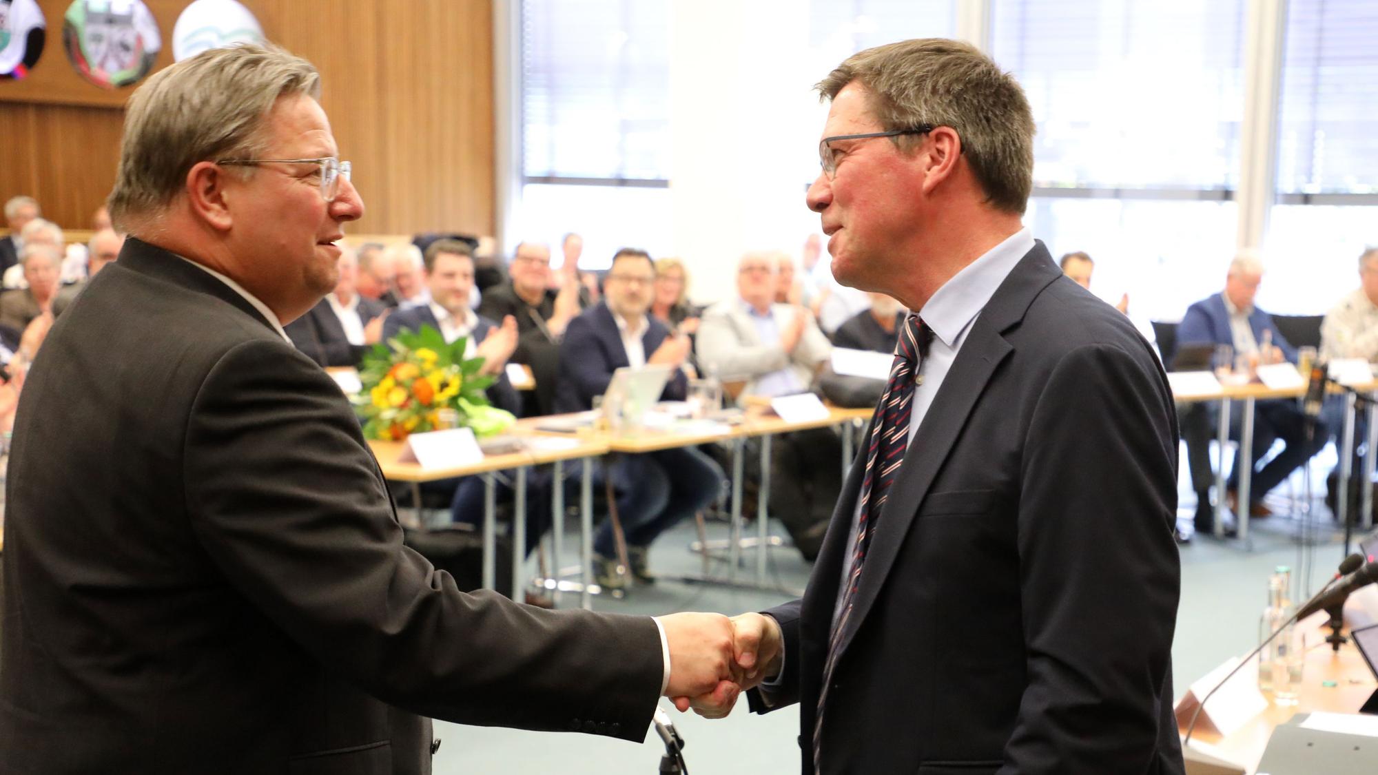 Landrat Stephan Santelmann gibt dem neuen Kreisdirektor Markus Fischer die Hand vor dem Kreistag.