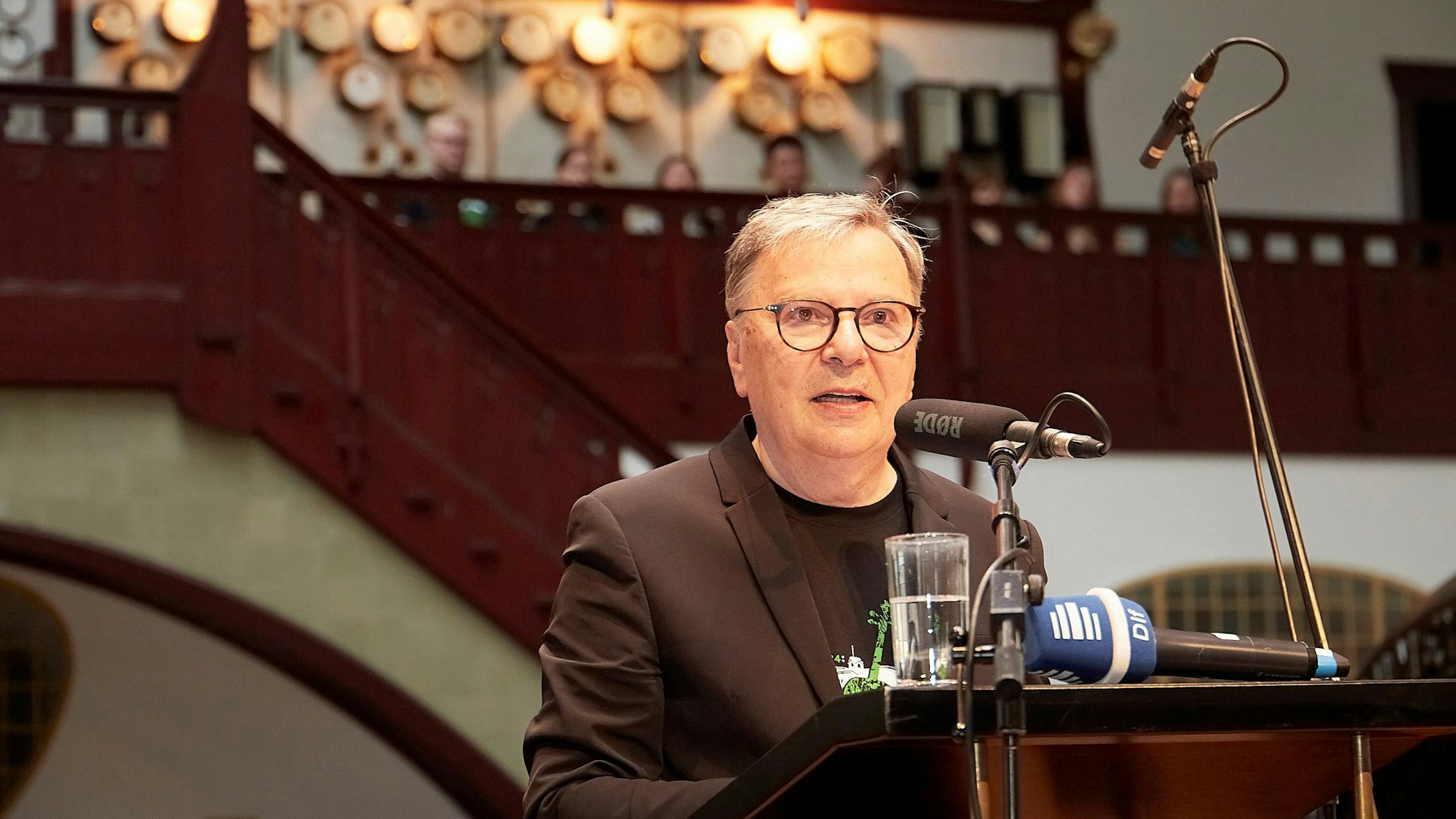 Dr. Hans-Joachim Güttler steht an einem Mikrofon.