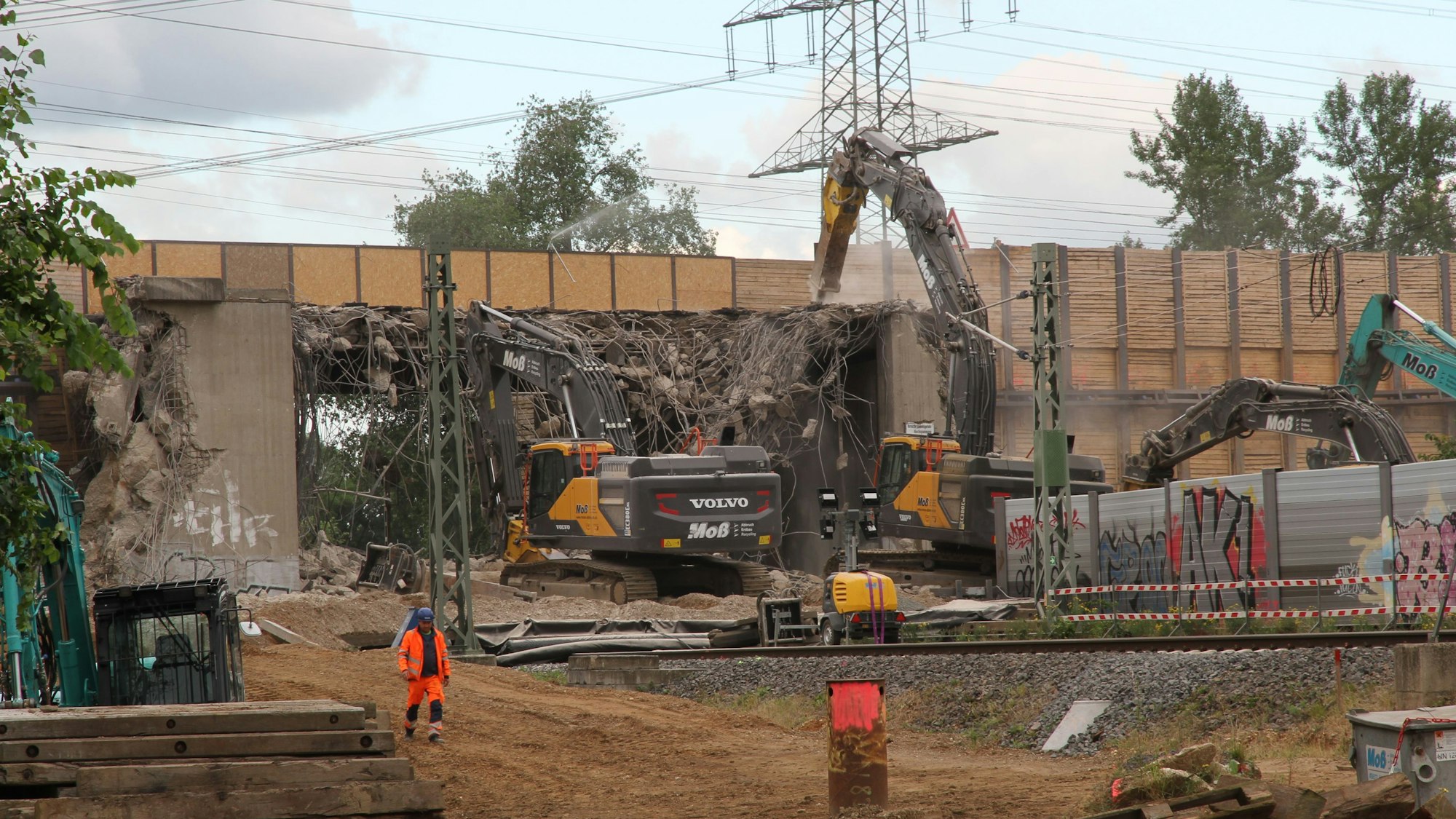 Schwere Bagger brechen den Teil einer Autobahnüberführung ab