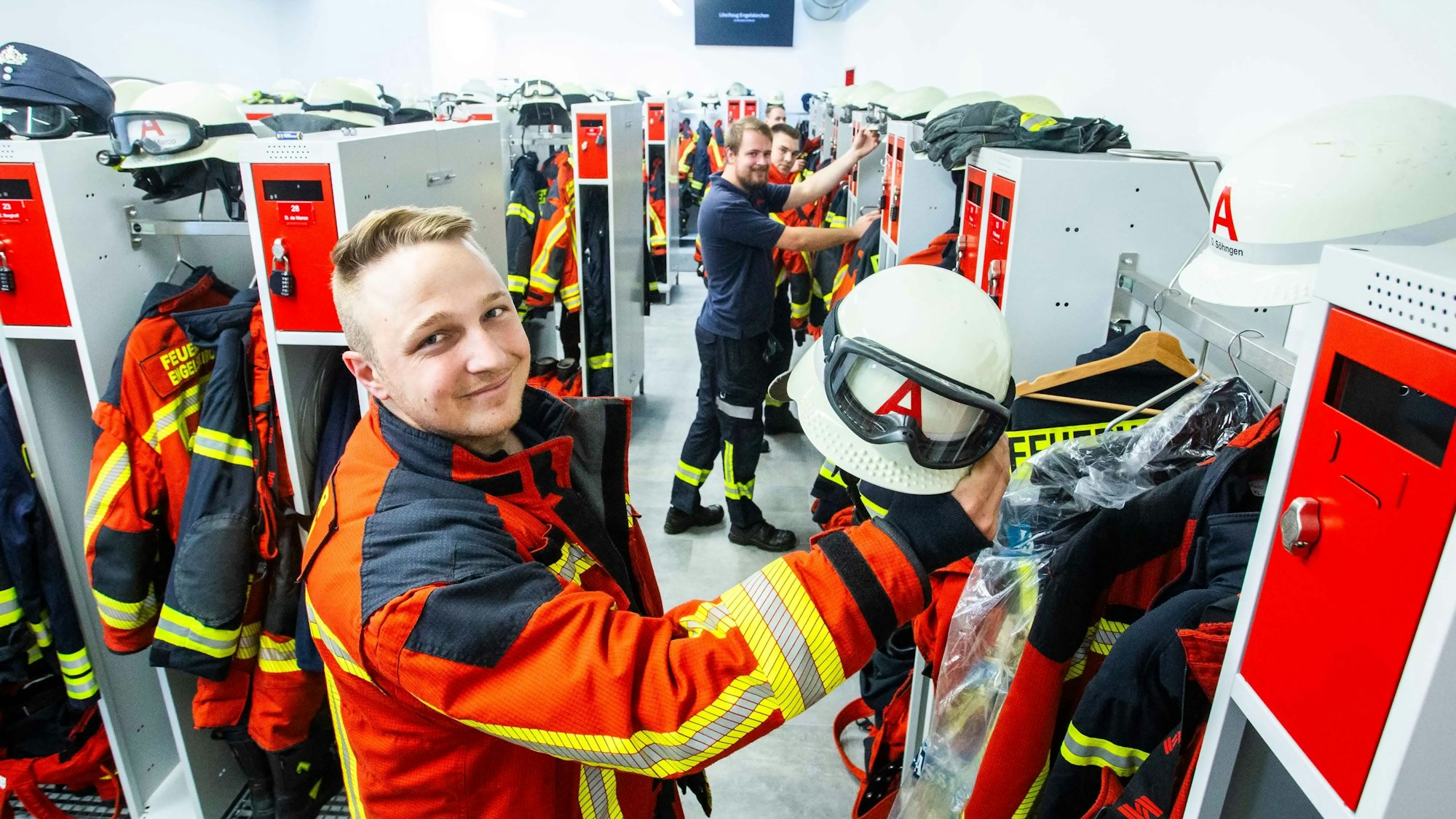 Das Foto zeigt Feuerwehrleute in der Umkleide der Feuerwache.