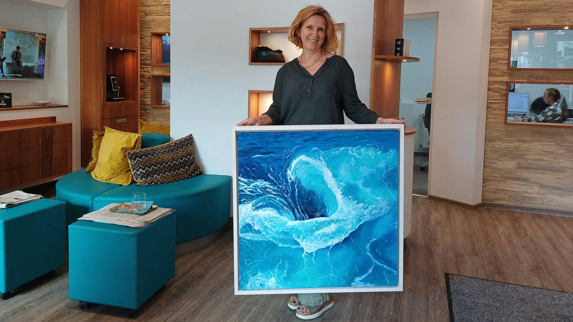 Eine Frau zeigt ein Gemälde in einem Geschäft.