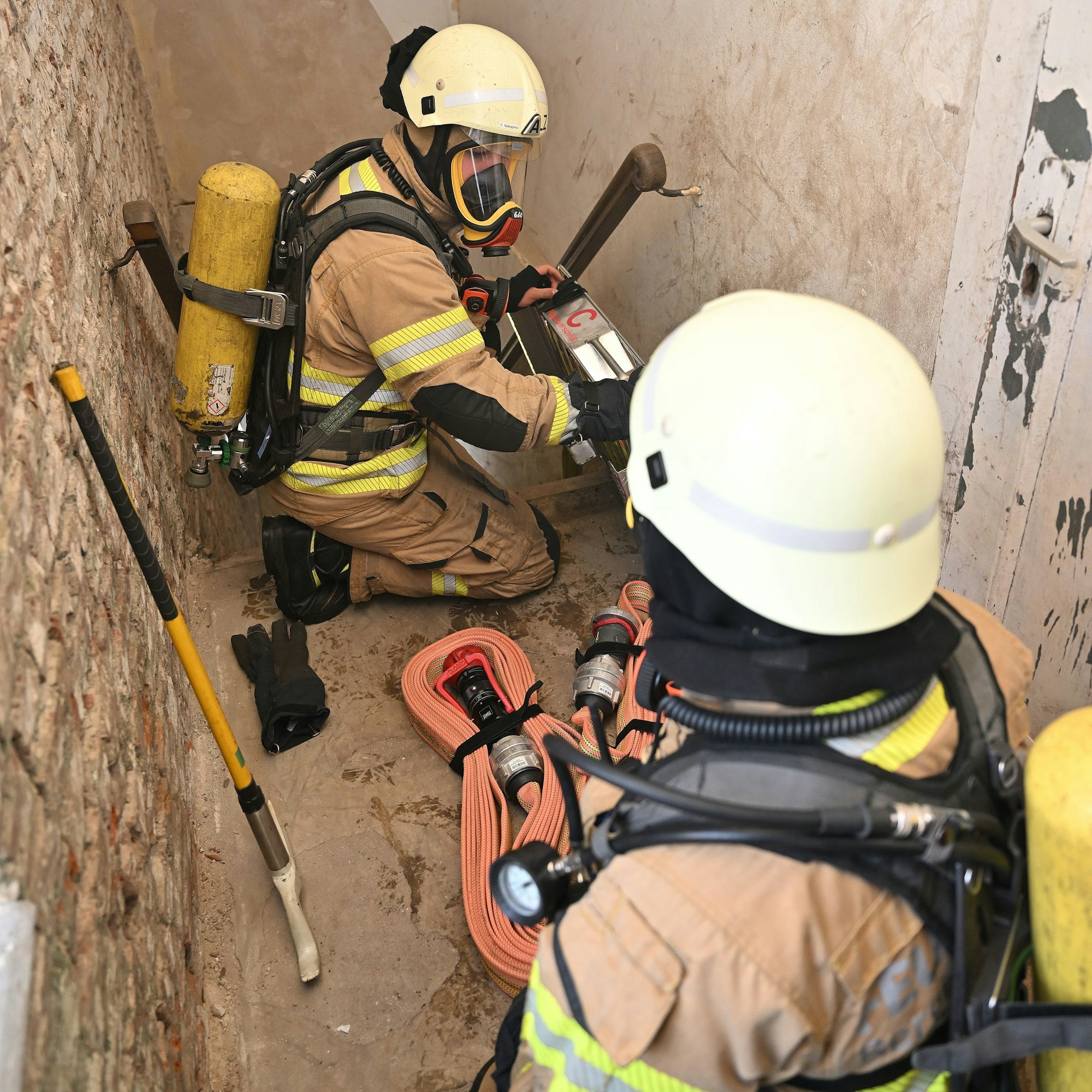 Zwei Feuerwehrleute arbeiten unter Atemschutz in einem Treppenhaus auf dem Zanders-Gelände bei der Großübung der Feuerwehr Bergisch Gladbach am Samstag (22.06.).