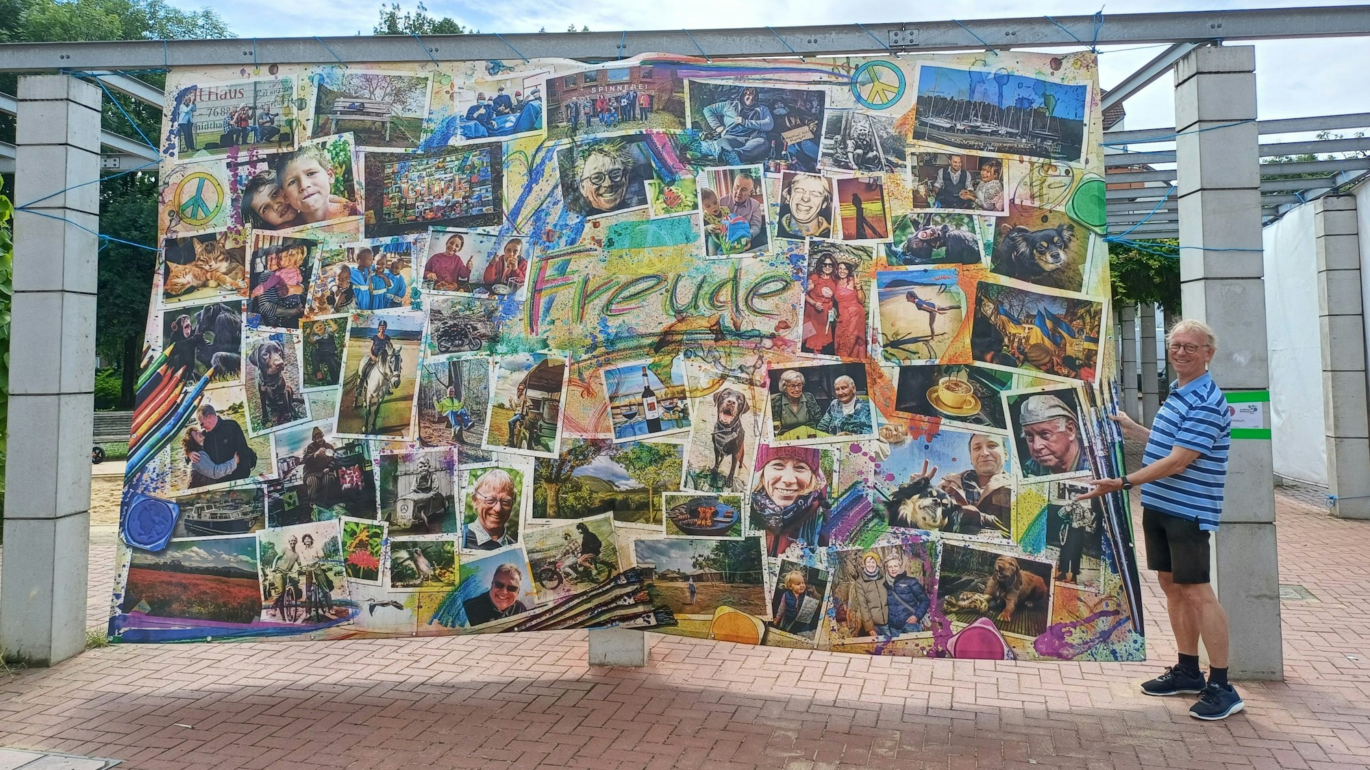 Ein Künstler steht neben einer Fotocollage