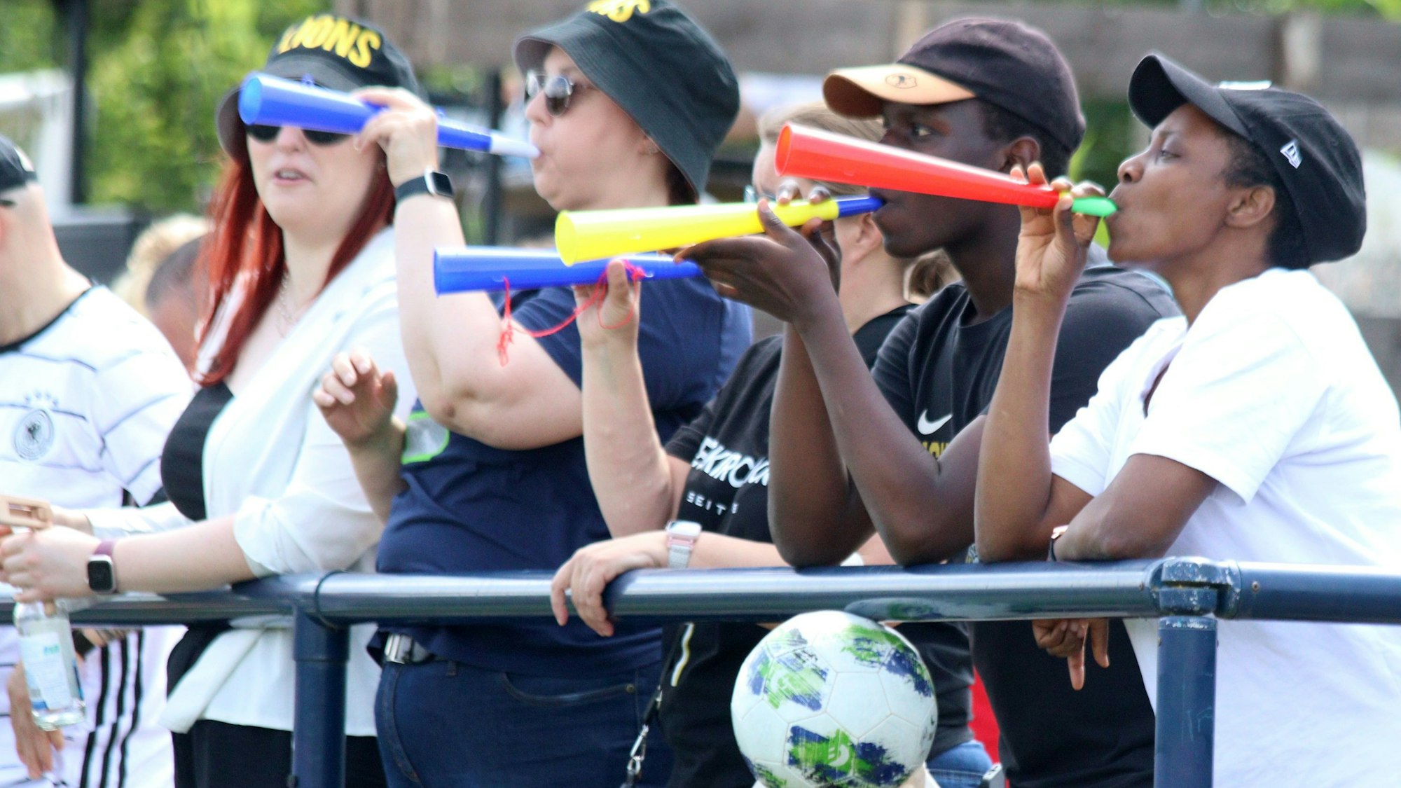 Fans der Euskirchen Lions stehen am Spielfeldrand und blasen in eine Vuvuzela.