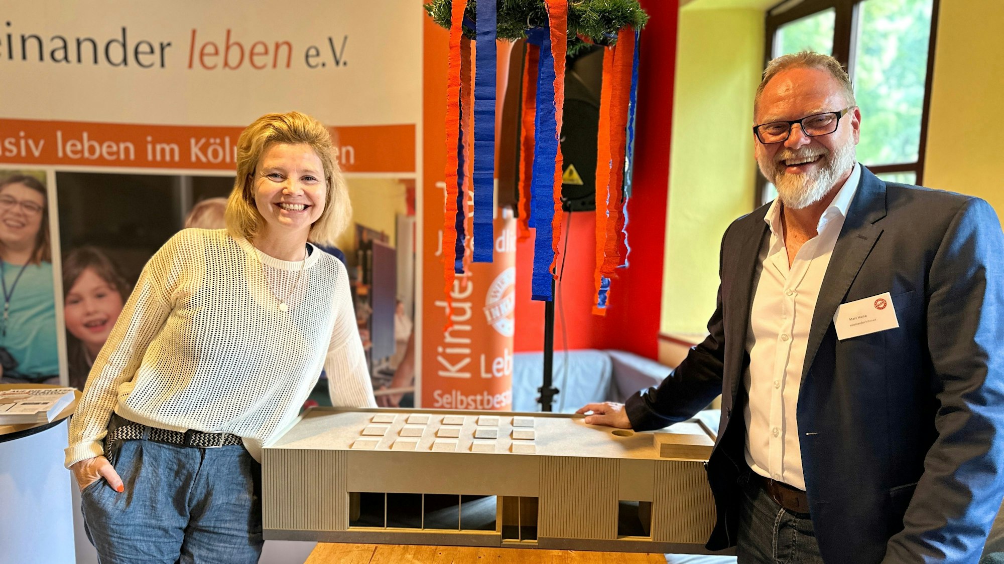 Annette Frier und Marc Haine neben dem Modell der Begegnungsstätte.