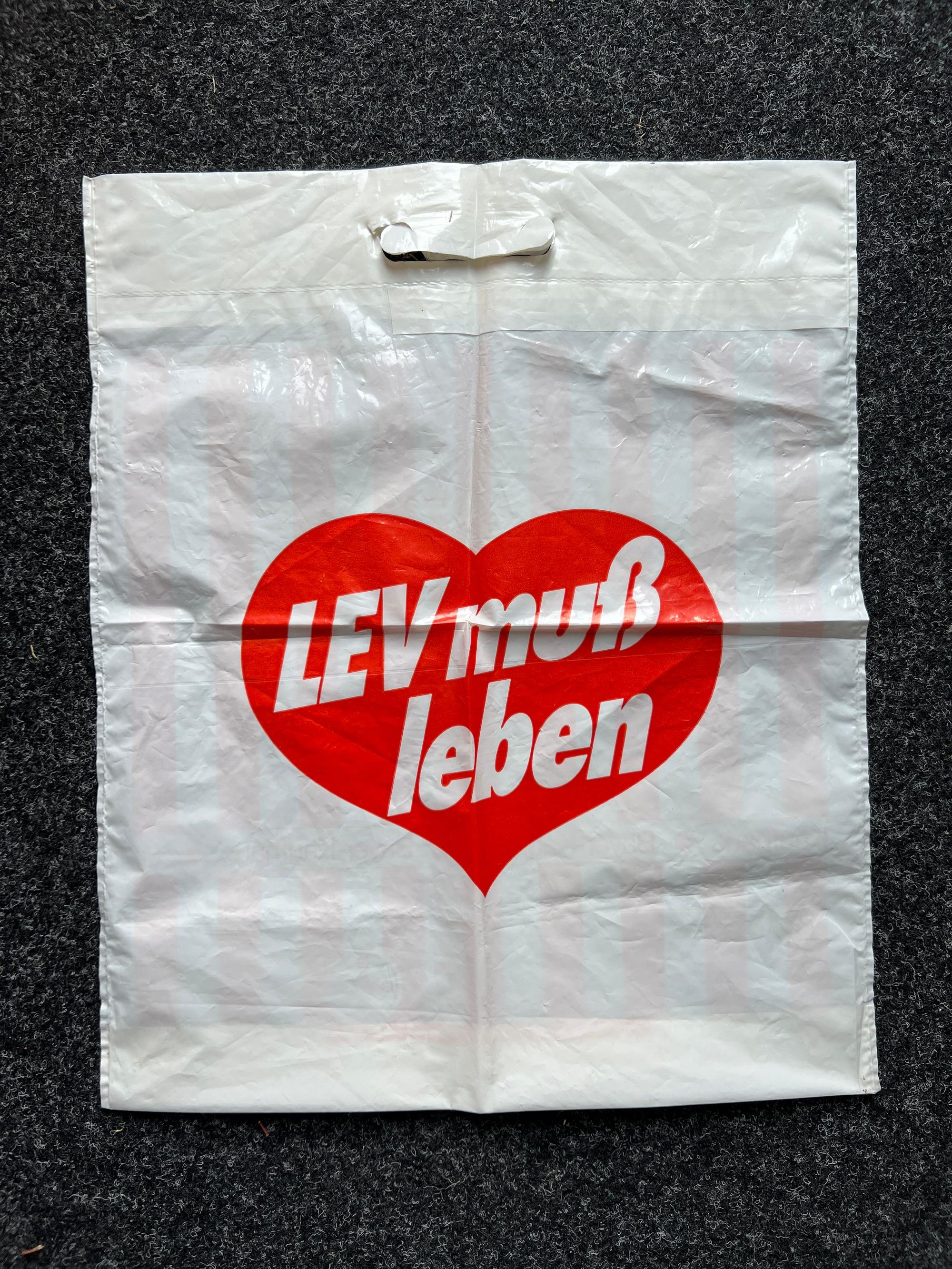 Eine Plastiktüte mit dem Slogan „Lev muss leben“, mit dem Leverkusen 1975 gegen die Eingemeindung nach Köln protestierte. Die gab es damals vom Bayer Kaufhaus.