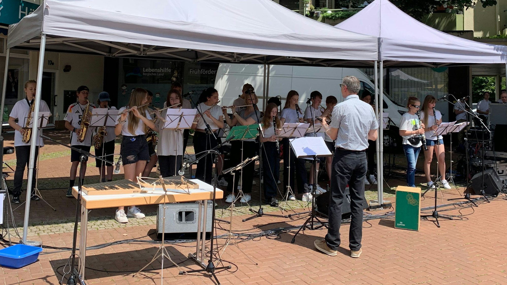 Ein Orchester aus Jugendlichen spielt, geleitet von einem Dirigenten.