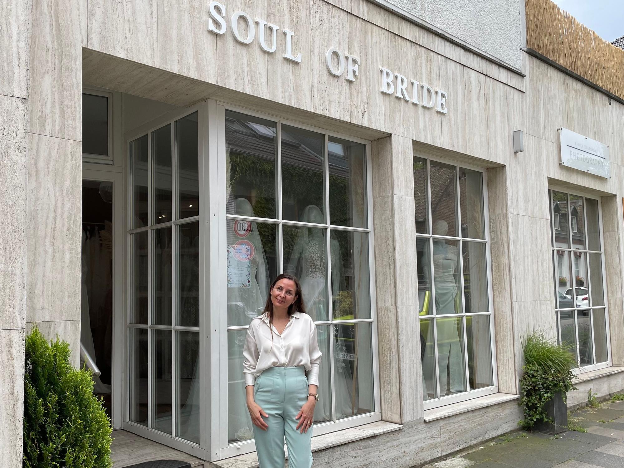 Besitzerin Kseniya Reyda steht vor dem Schaufenster ihres neuen Brautmodenladens